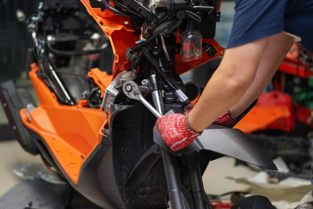 mechanic maintaining a motorcycle