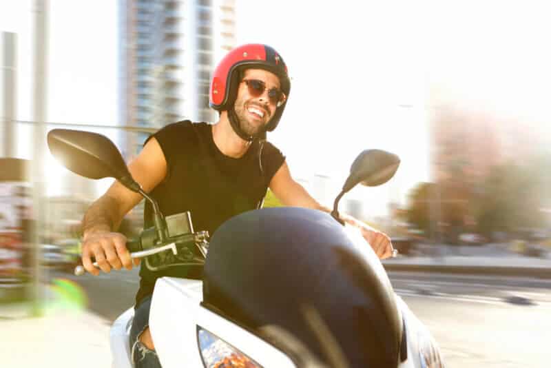 Portrait of handsome man on motorcycle ride in city smiling