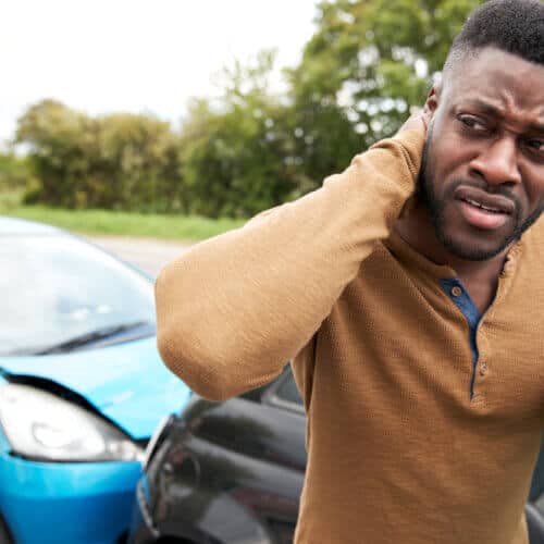 Male Motorist With Whiplash Injury In Car Crash Getting Out Of Vehicle