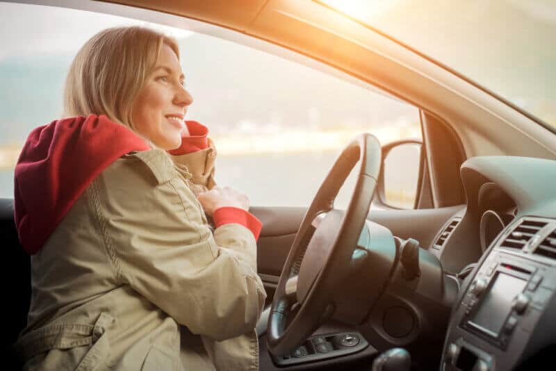 woman in coat driving car