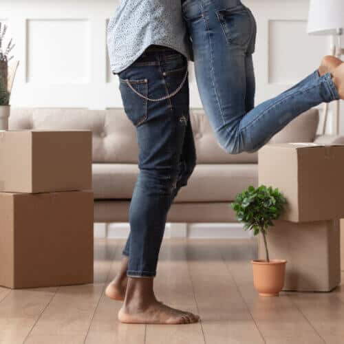 young couple standing in front of moving boxes