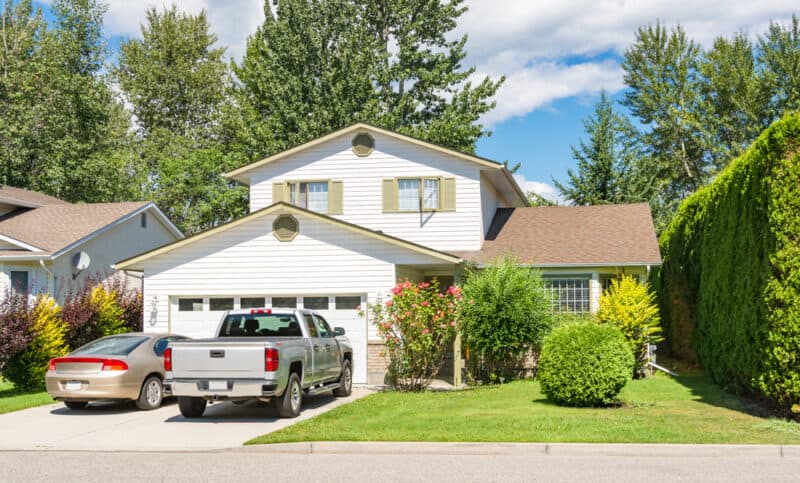 two cars parked in driveway of house