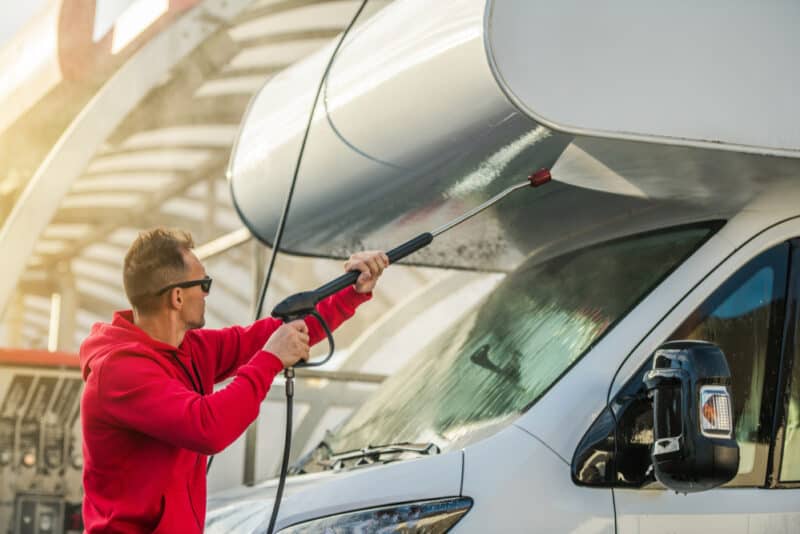 man washing exterior of rv