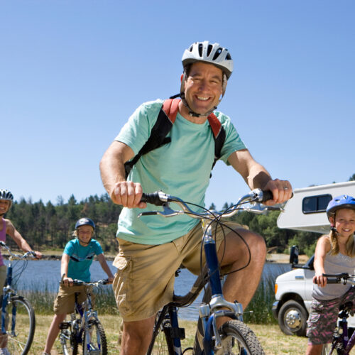 Family on bikes near their RV