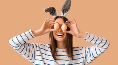 Silly young woman holding up eggs to her eyes with bunny ears.