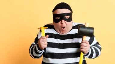 Chubby burglar in striped shirt and mask with sledgehammer and other tools - cheap home insurance in Washington.