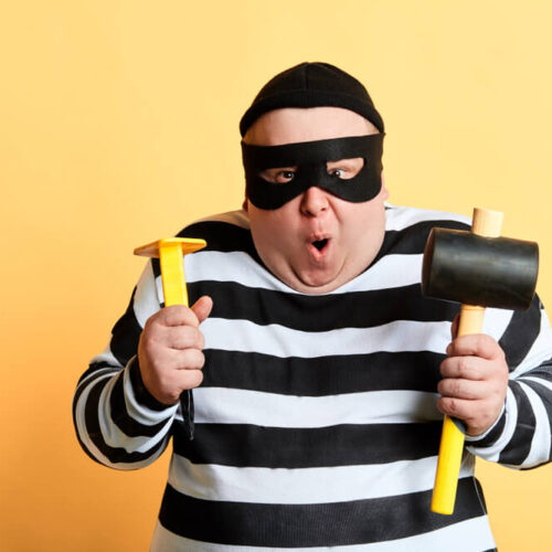 Chubby burglar in striped shirt and mask with sledgehammer and other tools - cheap home insurance in Washington.